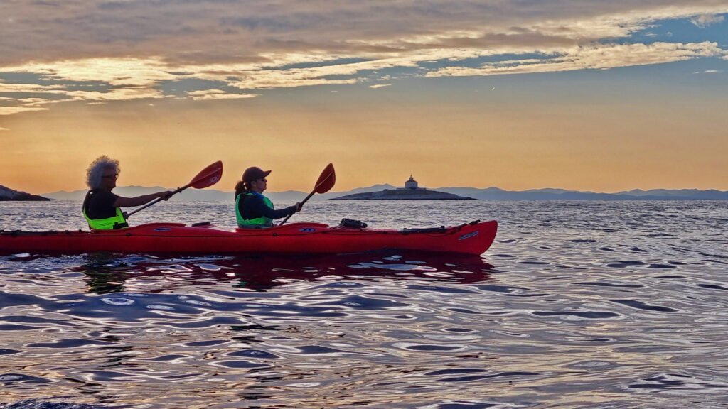 Sea kayakers paddling at sunset in Adriatic sea near Hvat town